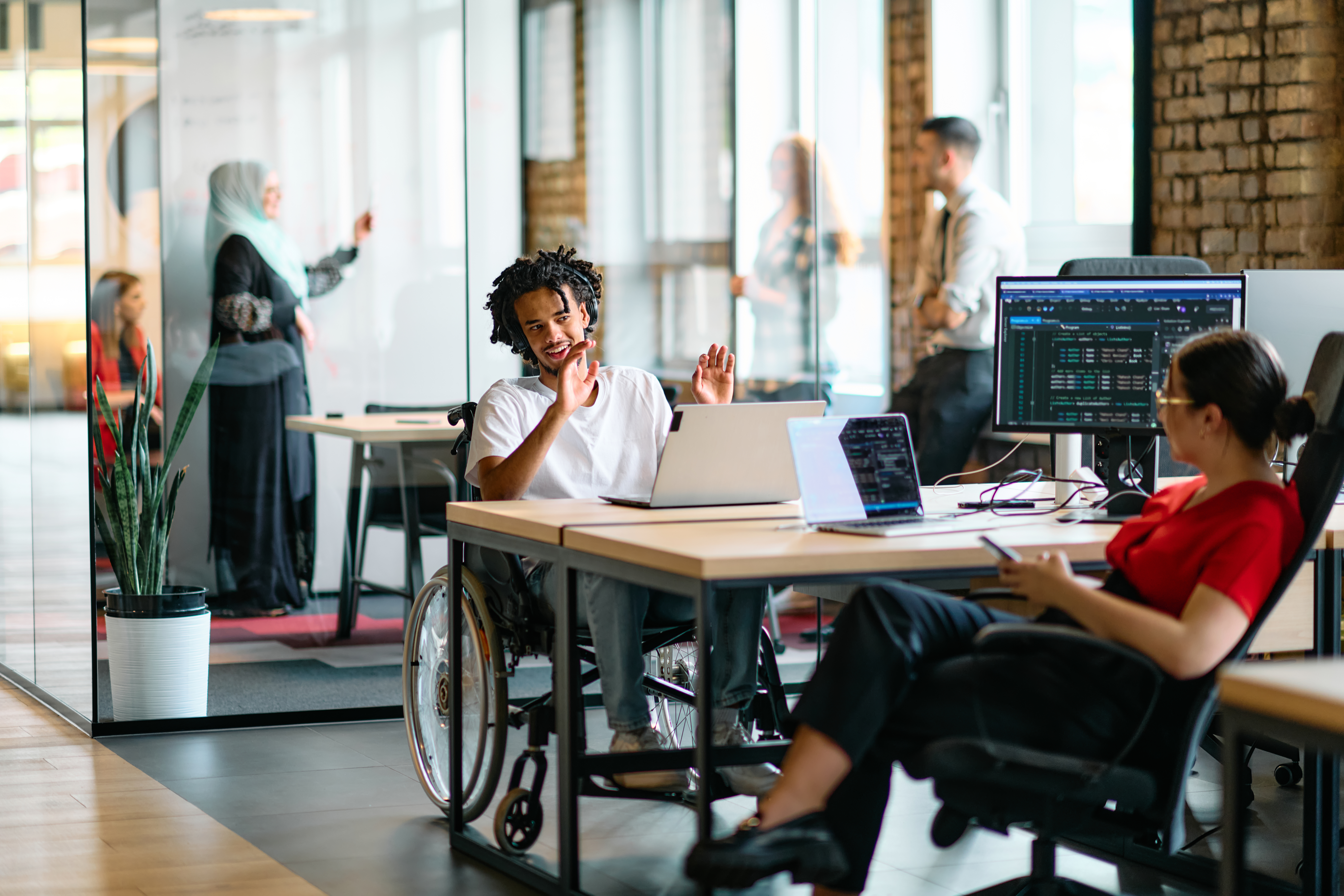 employee with wheelchair speaking with coworker